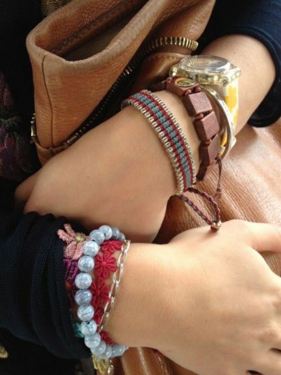 Närbild på Linns armband och väska. Närbild på Linns armband och väska.