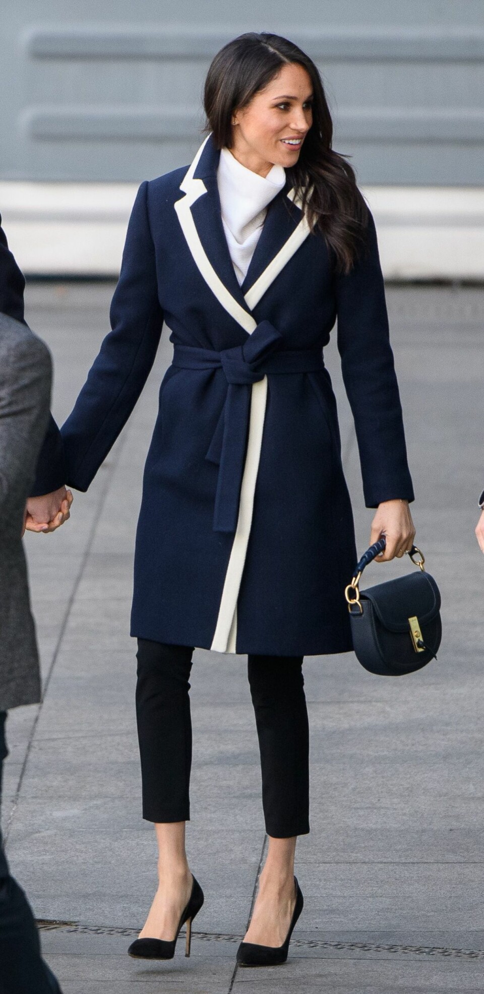 Meghan Markle i kappa från J Crew, svarta byxor och skor. Meghan Markle i kappa från J Crew, svarta byxor och skor.