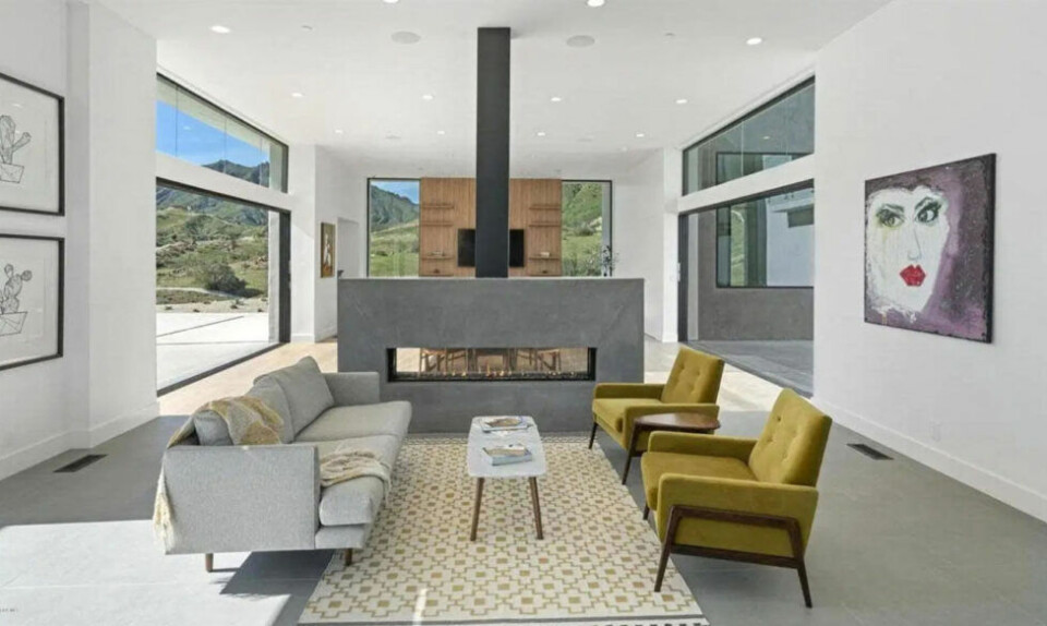 Mysigt rum där den platsbyggda kaminen agerar rumsavdelare. Mysigt rum där den platsbyggda kaminen agerar rumsavdelare.