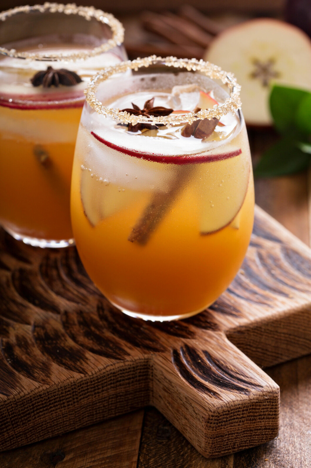 Apple cider cocktail with cinnamon and apple slices