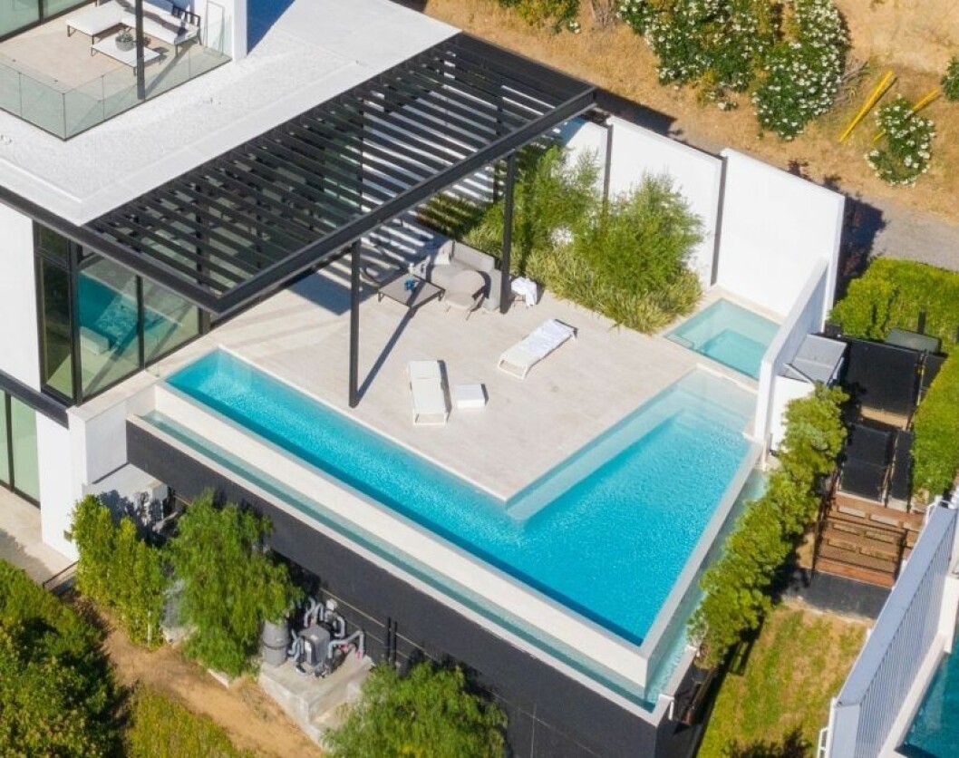 En fyrkantig pool utanför ett hus