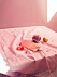 Frukter i stringtrosor på ett rosa bord under Arvida Byströms utställning Inflated Fiction.