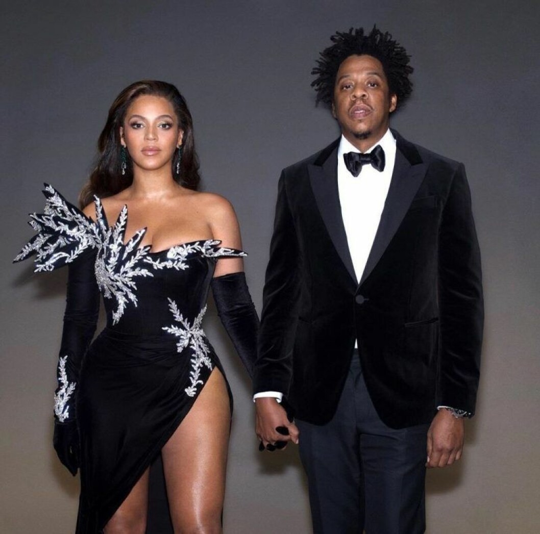 Beyoncé och Jay Z håller varandra i handen och tittar rakt fram