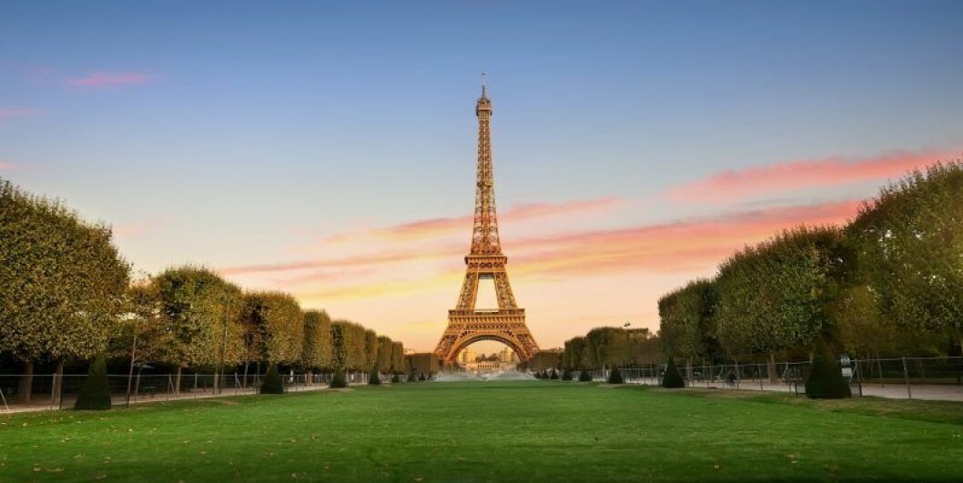 Eiffeltornet i paris med en grön gräsmatta framför