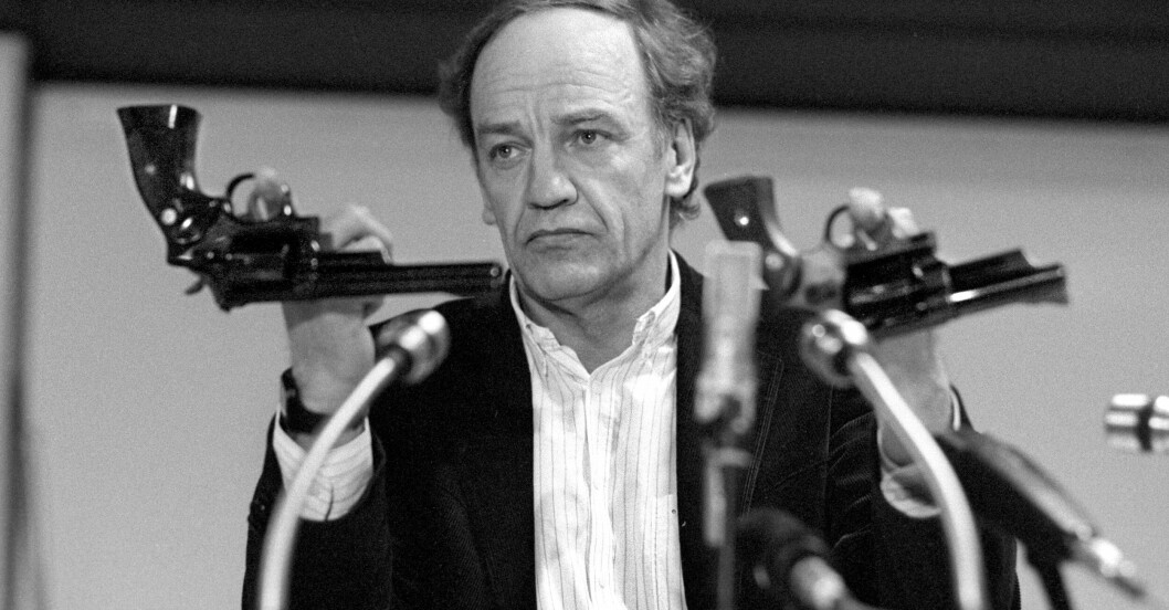 Hans Holmér håller upp två revolvrar av en typ som man misstänker överensstämmer med mordvapnet under en presskonferens 1986. Hans Holmér håller upp två revolvrar