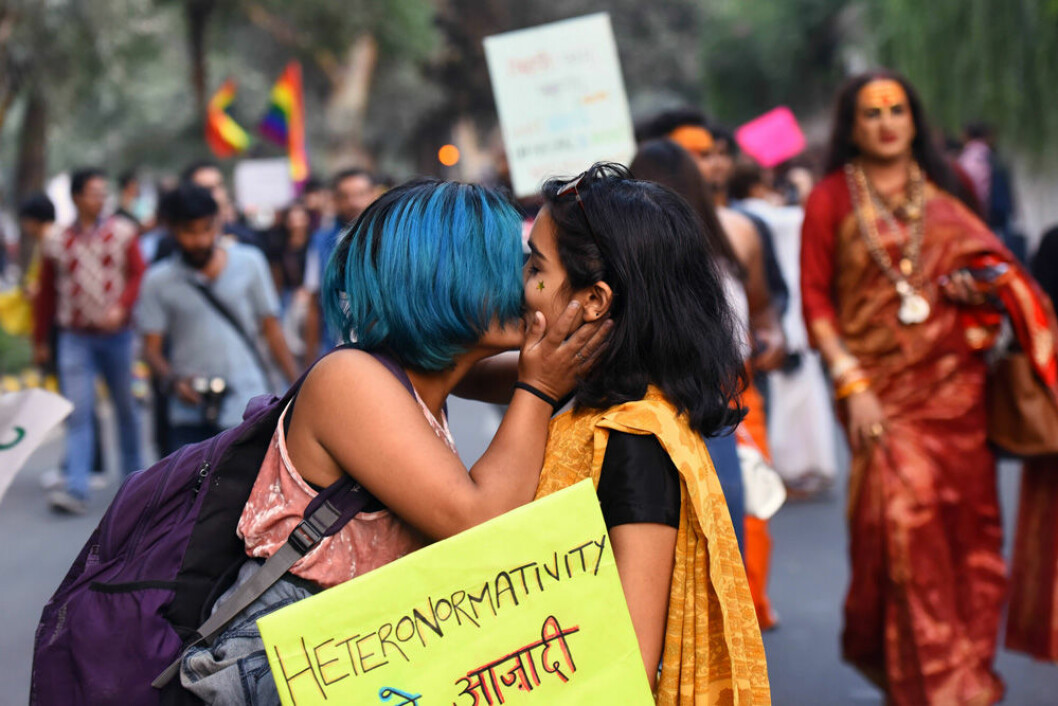 Homosexuellt par kysser varandra på öppen gata i Indien.