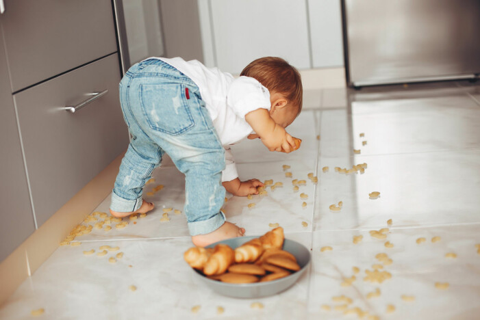 barn plockar mat på golvet