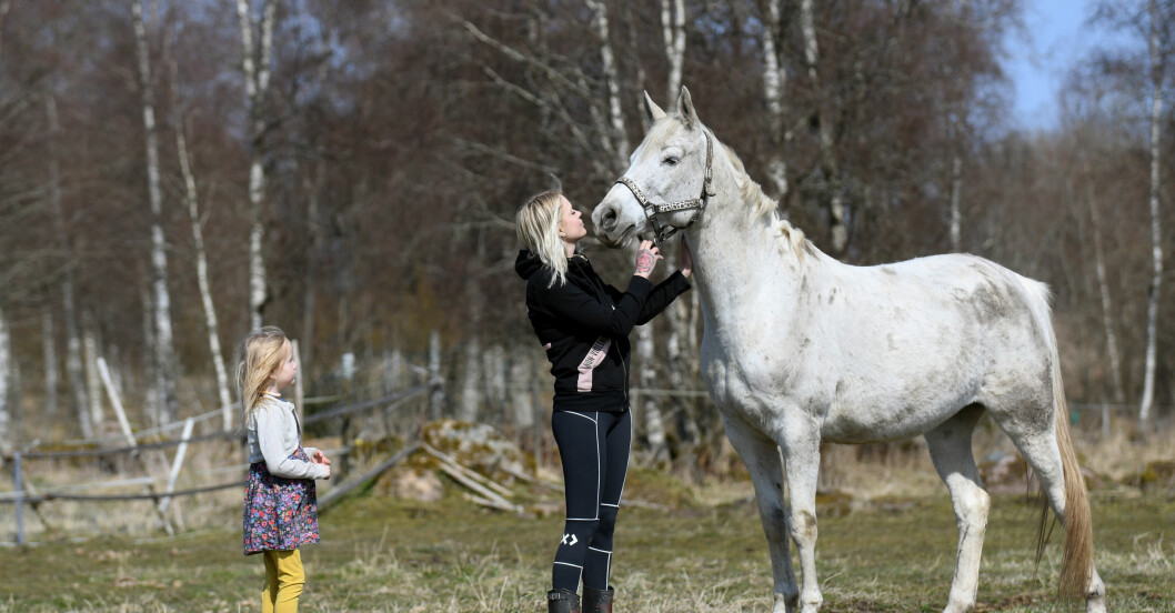 En kvinna, Natalie Eklind, med ett barn och en häst på en gård.
