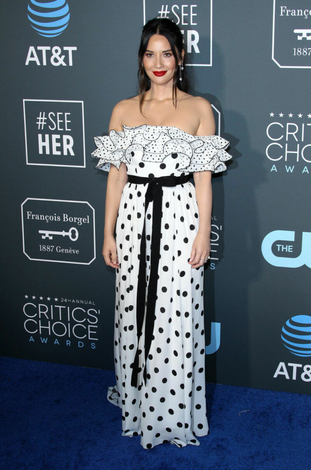 Olivia Munn klädd i prickig klänning med volang. Olivia Munn på röda mattan på Critics Choice Awards 2019