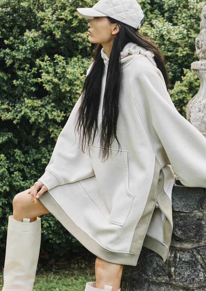 Quiltad keps, hoodie och boots från kollektionen – klicka på bilden för att komma direkt till kepsen. H&M modenyheter för dam hösten 2021 – lång beige hoodie och quiltad keps