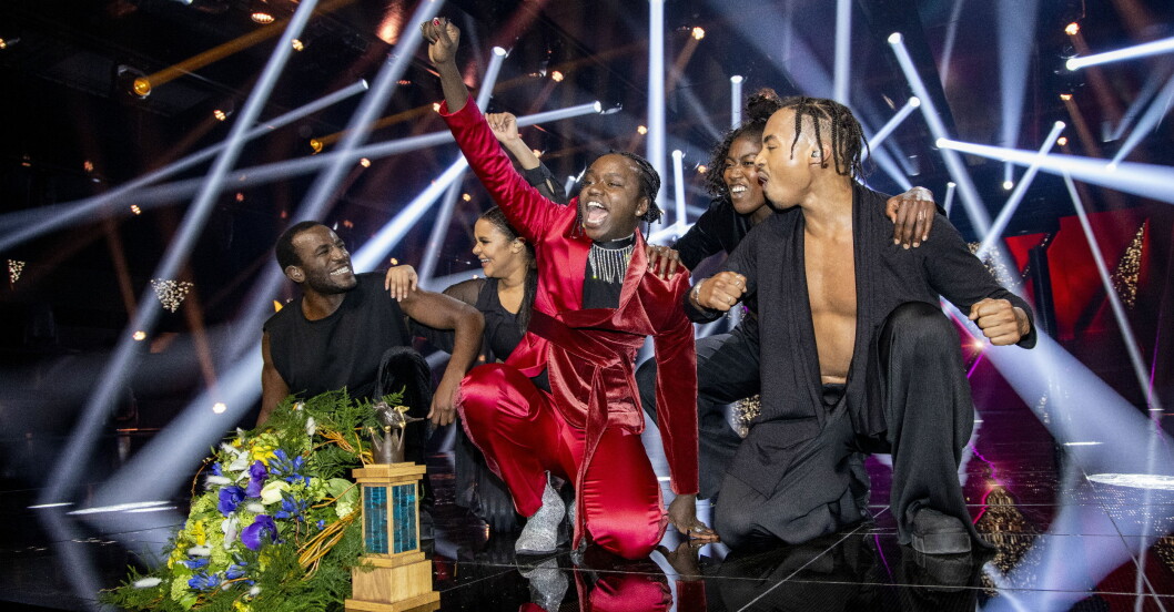 Tusse Chiza i röd kostym gör ett glädjerop i finalen på Melodifestivalen.
