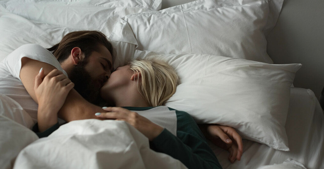en man och en kvinna ligger i sängen och kysser varandra
